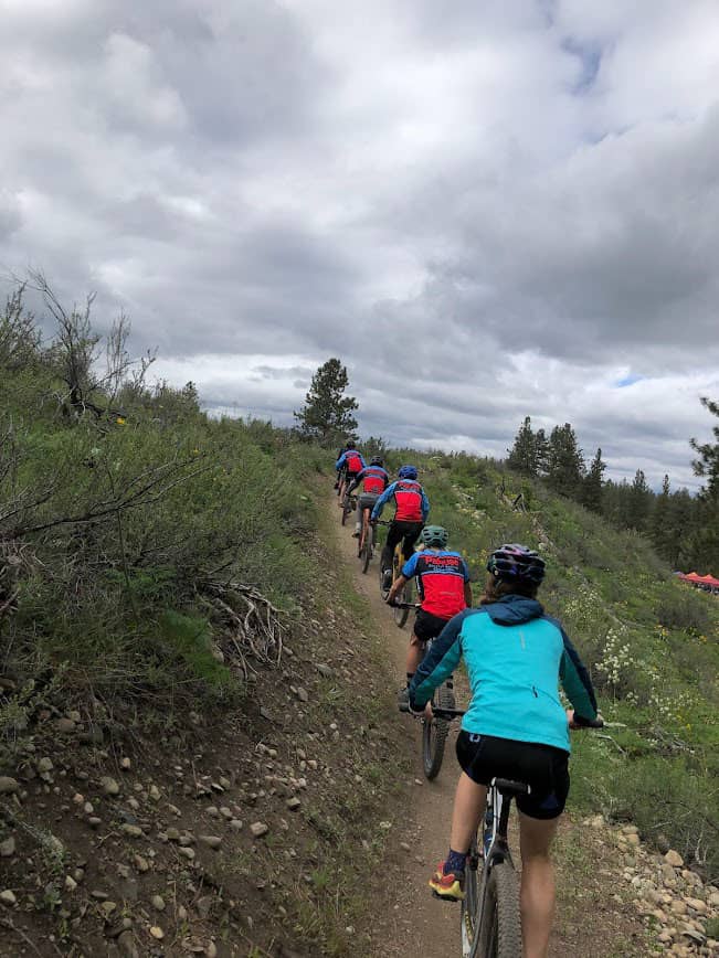 line of cyclists climbing up a trail