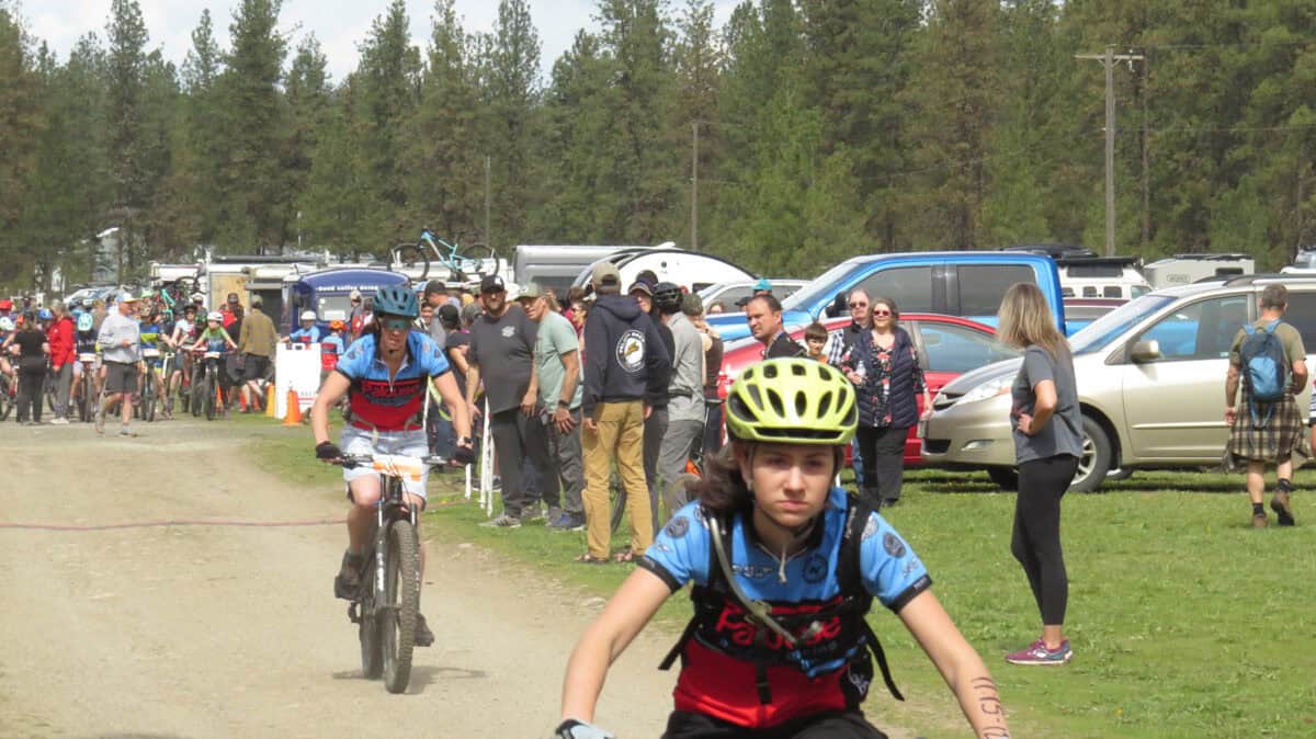 Two PBR cyclists in race with spectators in background